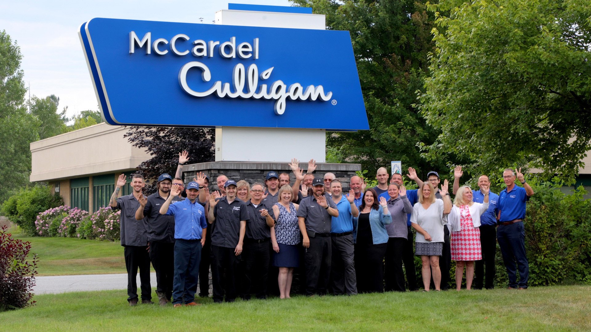 Staff posing for photo outside McCardel Culligan sign